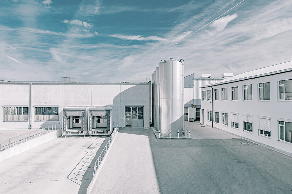 Exterior view of a modern industrial building under a clear blue sky.